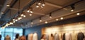 Modern track lighting installed in retail space ceiling. Adjustable fixtures illuminate merchandise display. Interior design, Royalty Free Stock Photo