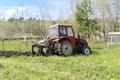 Modern tractor machinery plowing agricultural field meadow at farm at spring autumn. Farmer cultivating and make soil