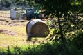 Modern tractor makes hay on a field