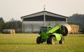 Modern tractor moving hay bales Royalty Free Stock Photo