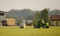 Modern tractor moving hay bales