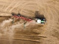 Modern tractor working on the agricultural field - aerial view  of a tractor plowing and sowing in the agricultural field - high Royalty Free Stock Photo