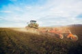 Modern tractor working on the farm, a modern agricultural transport, cultivation of fertile land, tractor on cloudy sky background