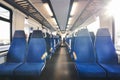 German train interior with two rows of empty seats and sunlight Royalty Free Stock Photo