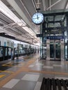 Modern Train Station Platform with Clock, Elevator, and Tactile Paving Royalty Free Stock Photo