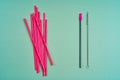 The modern trend towards caring for the environment. A pack of pink plastic beverage straws versus one reusable beverage straw