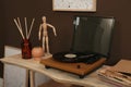 Modern turntable with vinyl disc on table indoors. Interior design