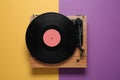 Modern turntable with vinyl record on color background, top view Royalty Free Stock Photo