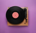 Modern turntable with vinyl record on purple background, top view Royalty Free Stock Photo