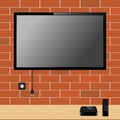 Modern TV with blank screen on brick wall and TV player box device with remote controller Royalty Free Stock Photo
