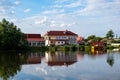 A modern two-storey house with a red tiled roof on the shore of a lake with a reflection in the water Royalty Free Stock Photo