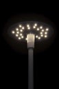 A modern, urban lantern on a pole burns at night, shines in the dark