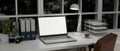 Modern urban office desk with laptop mockup, table lamp, binder, document tray on table