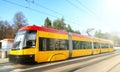 Modern urban rail transport. Yellow tram with motion blur effect moves fast in the city. High speed passenger train in motion on Royalty Free Stock Photo
