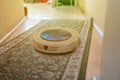 modern vacuum cleaner robot at home on floor, cleaning carpet, wireless new technology Royalty Free Stock Photo