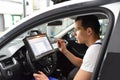 Modern vehicle diagnosis with computer in a garage - mechanic in