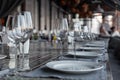 Modern veranda restaurant interior, banquet setting, glasses, plates