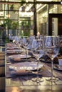 Modern veranda restaurant interior, banquet setting, glasses, plates