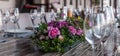 Modern veranda restaurant interior, flowers, banquet setting, glasses, plates
