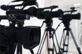 Modern video camera indoors, focus on lens. Professional media equipment for broadcasting event Royalty Free Stock Photo