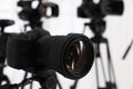 Modern video camera indoors, focus on lens. Professional media equipment for broadcasting event Royalty Free Stock Photo