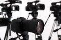 Modern video camera indoors, focus on lens. Professional media equipment for broadcasting event Royalty Free Stock Photo