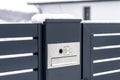 A modern videophone with a letterbox and a wireless card reader, mounted in panel fence in anthracite color, visible wicket, it ra Royalty Free Stock Photo