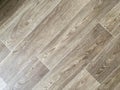 Modern vinyl floor with old wood imitation. Close-up of new beige flooring with texture from tiles with brown grains and knots. Royalty Free Stock Photo