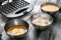 Modern waffle maker with ingredients on wooden table Royalty Free Stock Photo