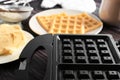 Modern waffle maker machine on wooden table Royalty Free Stock Photo