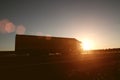 Modern wagon truck transports cargo against the backdrop of a sunset. The concept of truck drivers in the field of freight and