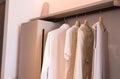 Modern walk in closets design interior with clothes hanging on rail warm tone