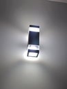 Modern wall lamp with minimalist rectangular design emitting soft white light Royalty Free Stock Photo