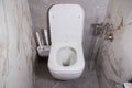 Modern wall-mounted toilet in the bathroom with gray porcelain stoneware tiles. Hygienic shower and toilet brushes Royalty Free Stock Photo