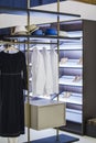 Modern wardrobe in the apartment with clothes and shelves for shoes. Shirts and dresses, hats and shoes in a fashionable dressing