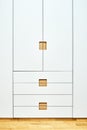 Modern wardrobe with finger pull design. Wooden wardrobe with light gray cabinet doors. Modern furniture Royalty Free Stock Photo