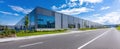 The modern warehouse building along a clear urban road under a blue sky. AI generated image Royalty Free Stock Photo