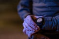 Modern warfare soldier checking navigation, time and other information on a smartwatch. Dark night black background.