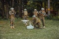 Modern Warfare Soldiers Squad are Using Drone for Scouting and Surveillance During Military Operation in the Forest. Royalty Free Stock Photo