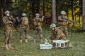 Modern Warfare Soldiers Squad are Using Drone for Scouting and Surveillance During Military Operation in the Forest. Royalty Free Stock Photo