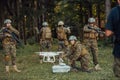 Modern Warfare Soldiers Squad are Using Drone for Scouting and Surveillance During Military Operation in the Forest. Royalty Free Stock Photo