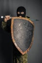 Modern warrior with medieval weapons in his hands. A soldier defends himself with a shield and attacks with a sword.