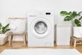 Modern washing machine, laundry in baskets and domestic room interior Royalty Free Stock Photo