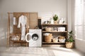 Modern washing machine and shelving unit in laundry room Royalty Free Stock Photo