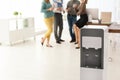 Modern water cooler and blurred office employees Royalty Free Stock Photo