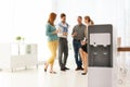 Modern water cooler and blurred office employees Royalty Free Stock Photo