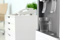 Modern water cooler with glass in office, closeup Royalty Free Stock Photo