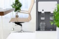 Modern water cooler with glass in office Royalty Free Stock Photo