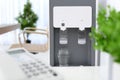 Modern water cooler with glass in office Royalty Free Stock Photo