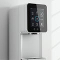 A modern water dispenser features a sleek, white design with a black touchscreen Royalty Free Stock Photo